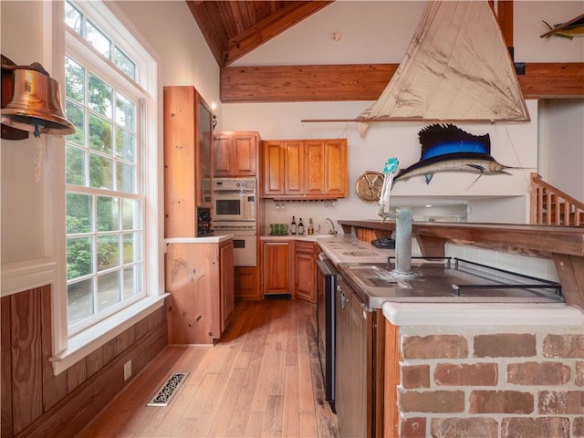 kitchen featuring brown cabinets, stainless steel double oven, wood ceiling, light wood-style flooring, and dishwasher