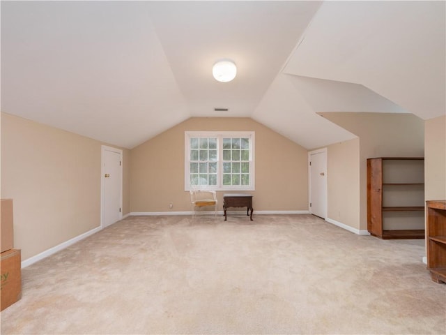 bonus room with light carpet, vaulted ceiling, and baseboards