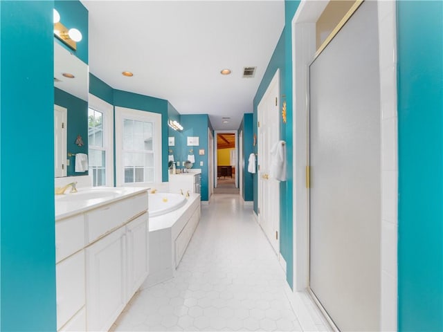 full bath featuring a garden tub, vanity, recessed lighting, and tile patterned floors