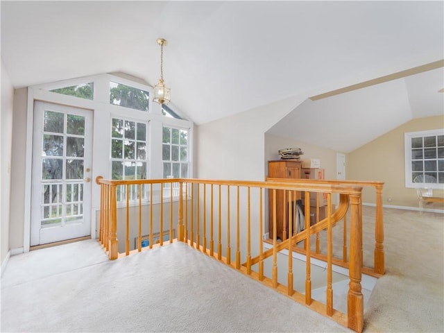 hallway with lofted ceiling, carpet, an upstairs landing, and baseboards