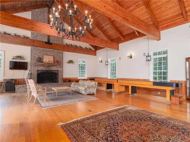 living room with wooden ceiling, a chandelier, a wainscoted wall, beamed ceiling, and wood finished floors