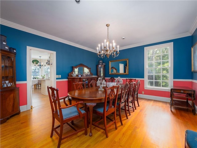 dining area with a chandelier, wood finished floors, crown molding, and baseboards