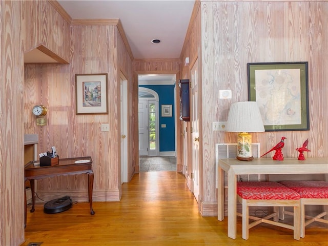 corridor with baseboards, wood finished floors, and wooden walls