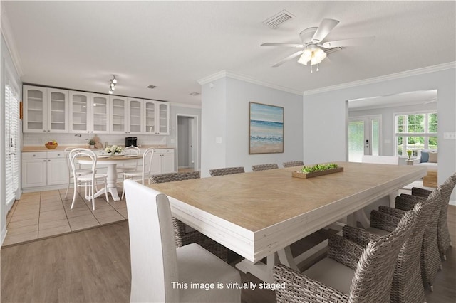 701 Third Ave, Saint Simons Island, GA 31522 - dining area with ceiling fan, light wood-type flooring, visible vents, and ornamental molding