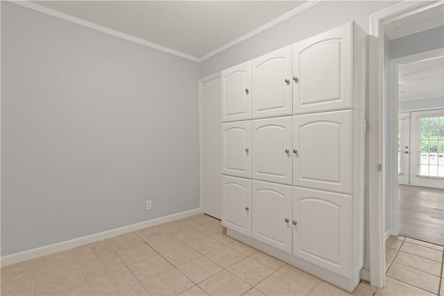 701 Third Ave, Saint Simons Island, GA 31522 - unfurnished bedroom with baseboards, a closet, crown molding, and light tile patterned flooring