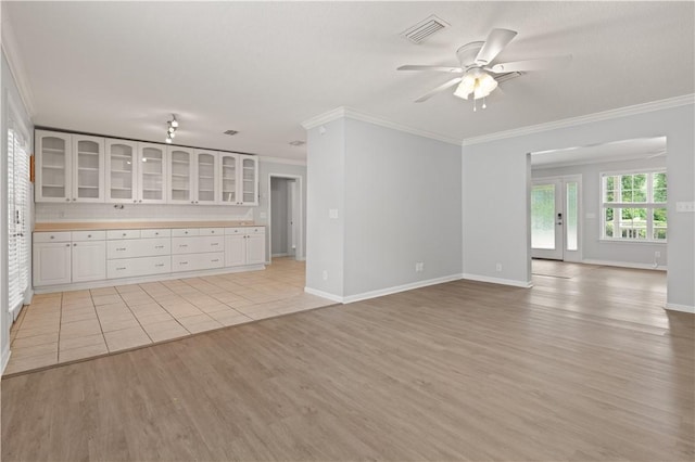 701 Third Ave, Saint Simons Island, GA 31522 - unfurnished living room with light wood-type flooring, ceiling fan, ornamental molding, and visible vents