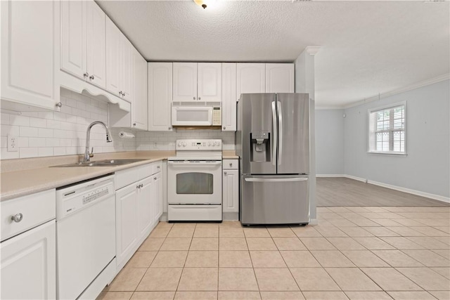 701 Third Ave, Saint Simons Island, GA 31522 - kitchen with a sink, white appliances, white cabinetry, and light countertops