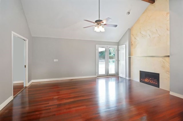 104 Cay Trce, Brunswick, GA 31525 - unfurnished living room featuring lofted ceiling, wood finished floors, a ceiling fan, a tiled fireplace, and baseboards