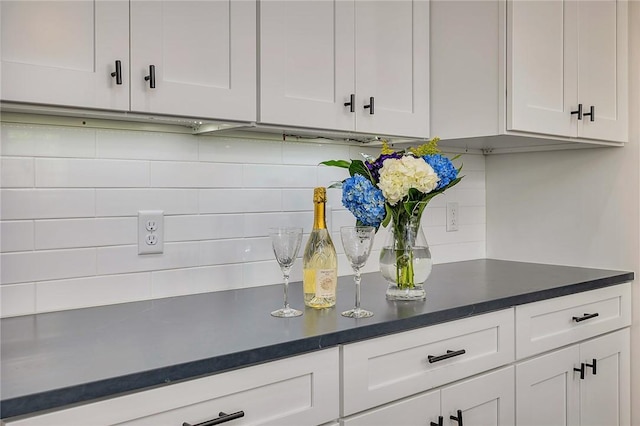 11826 Old Demere Rd, Saint Simons Island, GA 31522 - kitchen featuring backsplash, white cabinets, and dark countertops