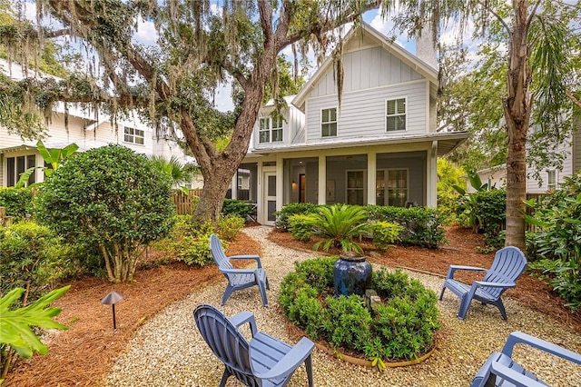 11826 Old Demere Rd, Saint Simons Island, GA 31522 - rear view of property featuring board and batten siding, a sunroom, and a chimney