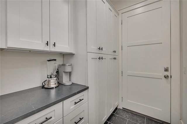 11826 Old Demere Rd, Saint Simons Island, GA 31522 - kitchen featuring dark countertops, white cabinets, and dark tile patterned floors