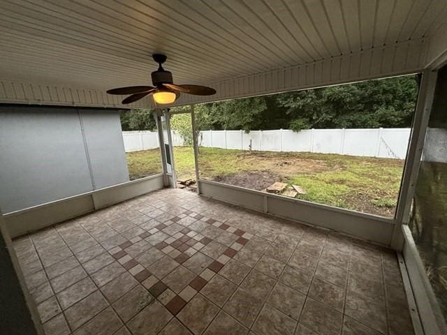 unfurnished sunroom with ceiling fan