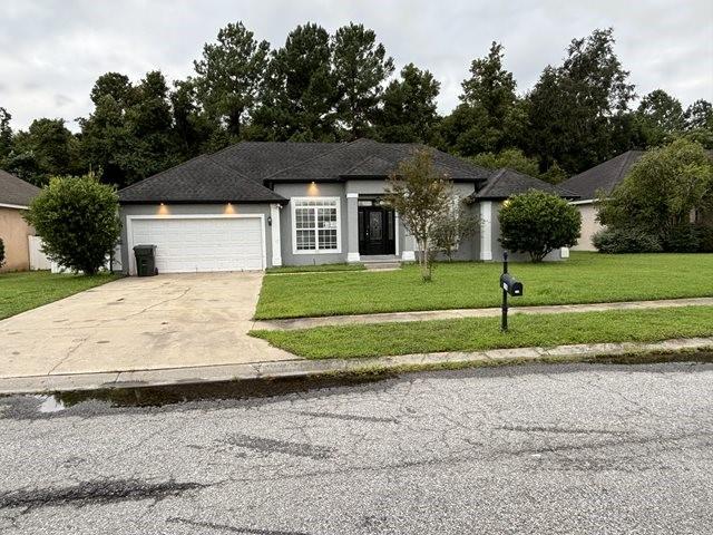 view of front of property featuring a front yard and a garage