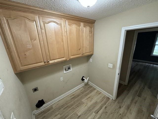 laundry room with hookup for an electric dryer, washer hookup, cabinets, a textured ceiling, and hardwood / wood-style floors