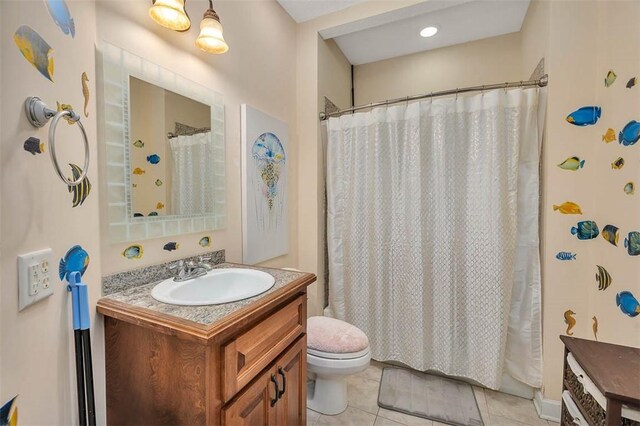 bathroom with tile patterned flooring, vanity, and toilet