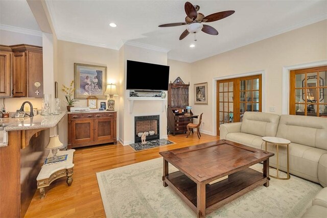 living room with french doors, light hardwood / wood-style floors, ceiling fan, and ornamental molding