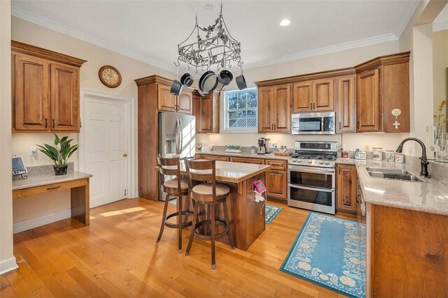 kitchen with stainless steel appliances, a kitchen island, light hardwood / wood-style floors, and sink