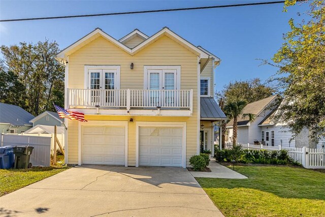 view of front facade with a balcony, a front lawn, and a garage