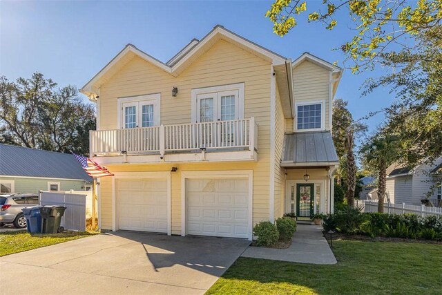 view of front facade with a balcony, a front yard, and a garage