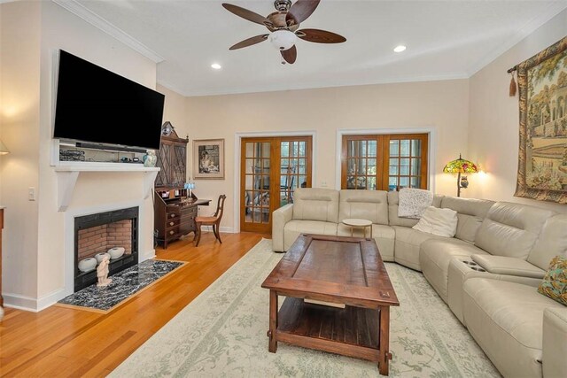 living room featuring crown molding, french doors, ceiling fan, and light hardwood / wood-style floors