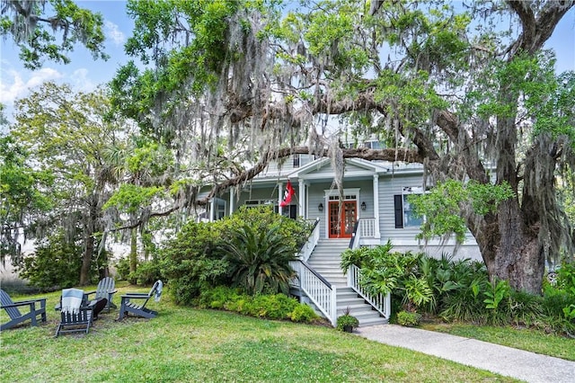 view of front of house with french doors, a porch, stairway, and a front yard