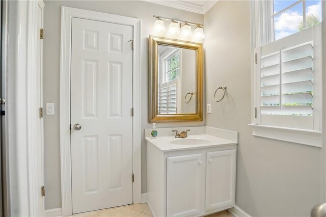 bathroom with crown molding, baseboards, tile patterned floors, and vanity