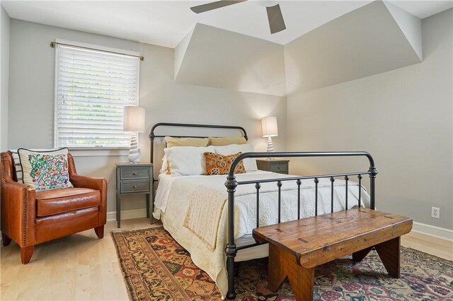 bedroom with light wood-style floors, baseboards, and ceiling fan