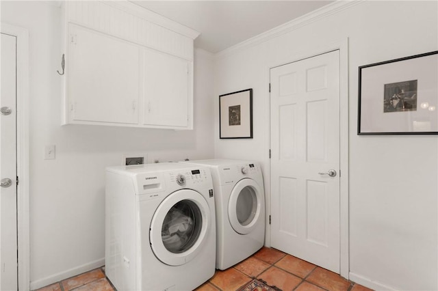 laundry room with crown molding, light tile patterned flooring, baseboards, washer and clothes dryer, and cabinet space