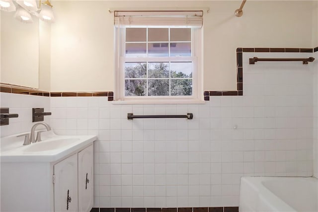 bathroom with a bathing tub, vanity, and tile walls