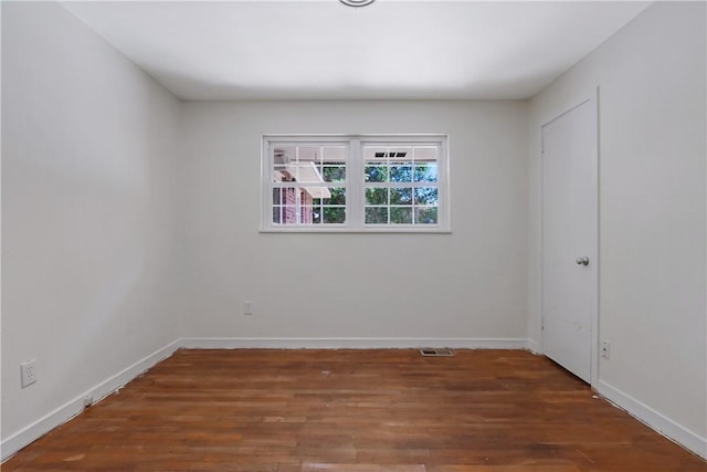 unfurnished room featuring dark wood-type flooring