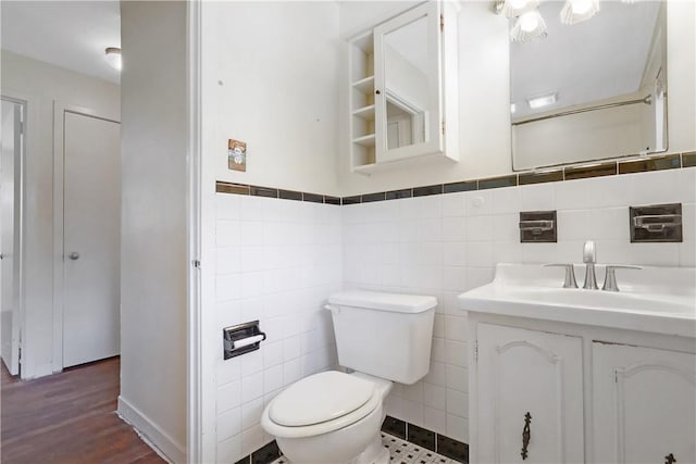 bathroom with vanity, wood-type flooring, tile walls, and toilet