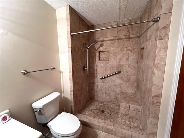 bathroom with tiled shower, a textured ceiling, and toilet