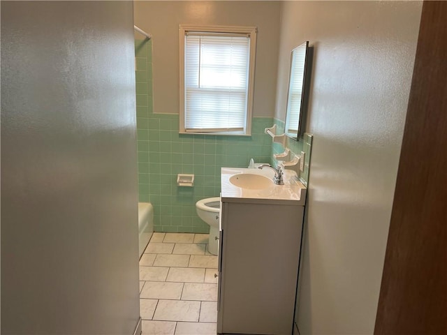 full bathroom with vanity, bathtub / shower combination, tile patterned flooring, toilet, and tile walls