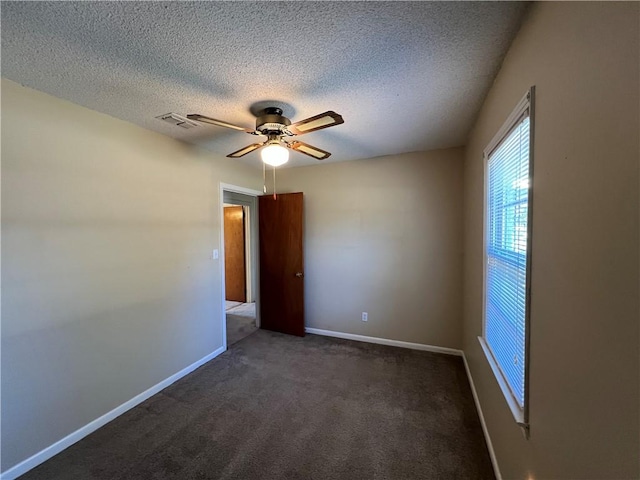 carpeted spare room featuring ceiling fan and a textured ceiling