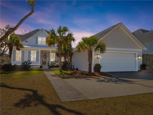 view of front of property featuring concrete driveway, fence, and an attached garage