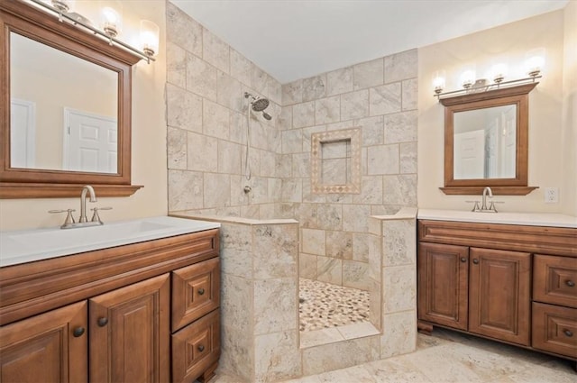 bathroom featuring a sink, walk in shower, and two vanities