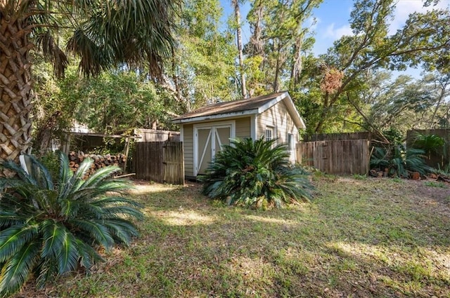 view of yard featuring an outdoor structure, a storage unit, and fence