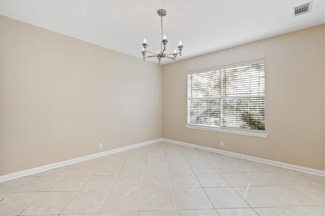 spare room with a notable chandelier, baseboards, visible vents, and light tile patterned floors