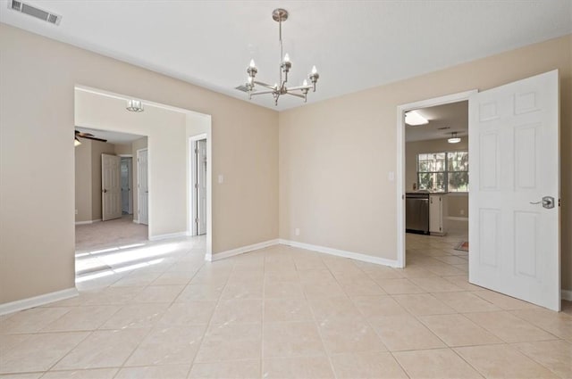 empty room with light tile patterned floors, visible vents, baseboards, and ceiling fan with notable chandelier