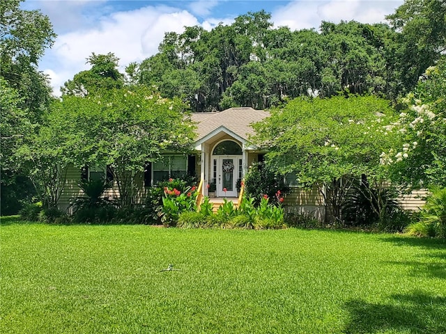 view of front of home with a front lawn and a shingled roof