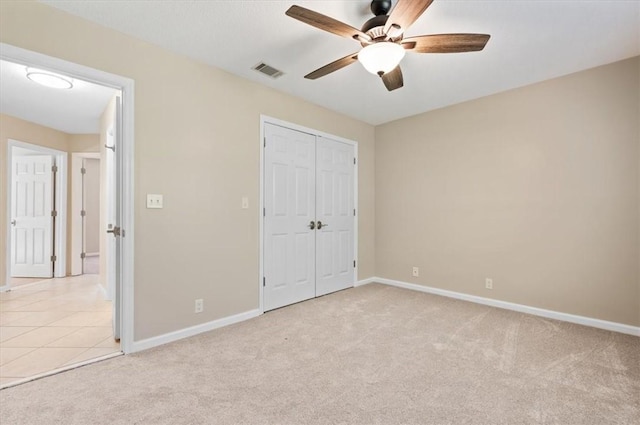 unfurnished bedroom featuring visible vents, baseboards, light colored carpet, and a closet