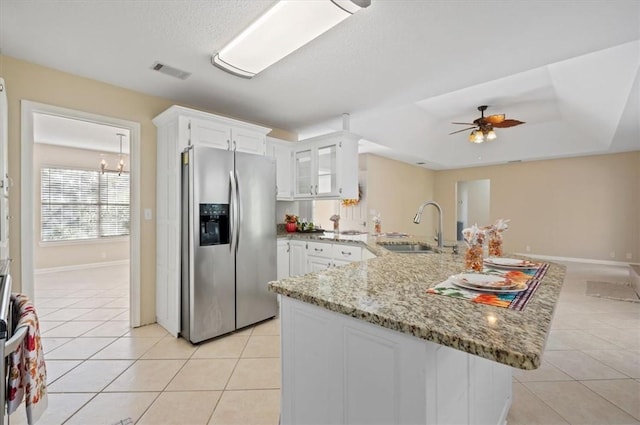 kitchen featuring visible vents, light tile patterned floors, light stone counters, stainless steel refrigerator with ice dispenser, and a sink