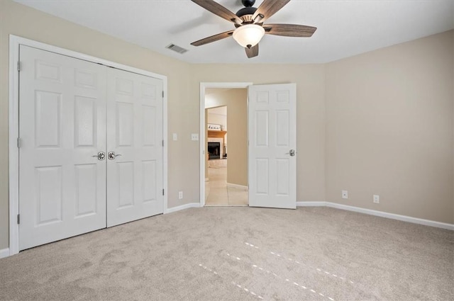 unfurnished bedroom featuring visible vents, a fireplace, baseboards, and carpet