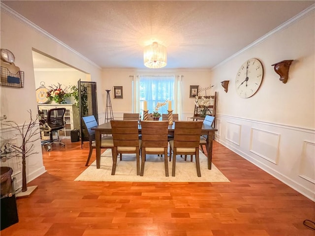 dining space featuring hardwood / wood-style floors, an inviting chandelier, and crown molding