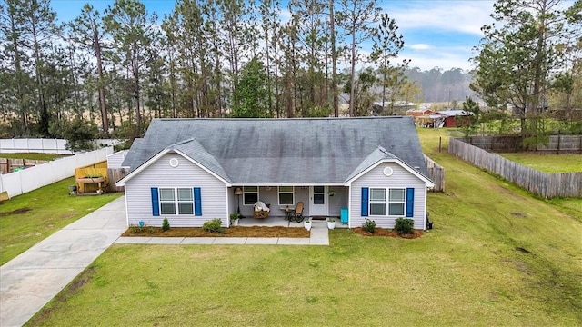 203 Hendrix St NE, Ludowici, GA 31316 - view of front of home with a shingled roof, a front yard, covered porch, and fence