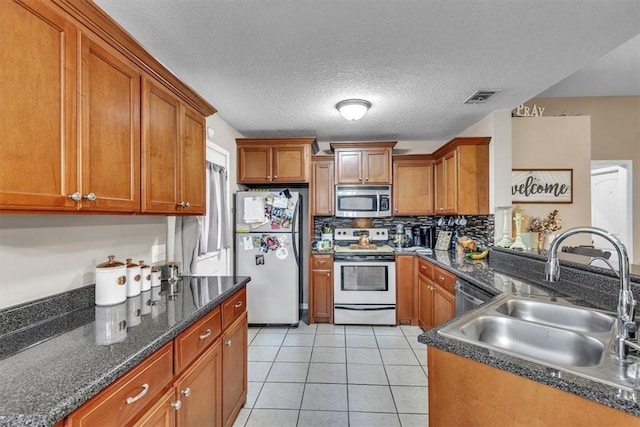 203 Hendrix St NE, Ludowici, GA 31316 - kitchen with light tile patterned floors, a sink, visible vents, appliances with stainless steel finishes, and brown cabinets
