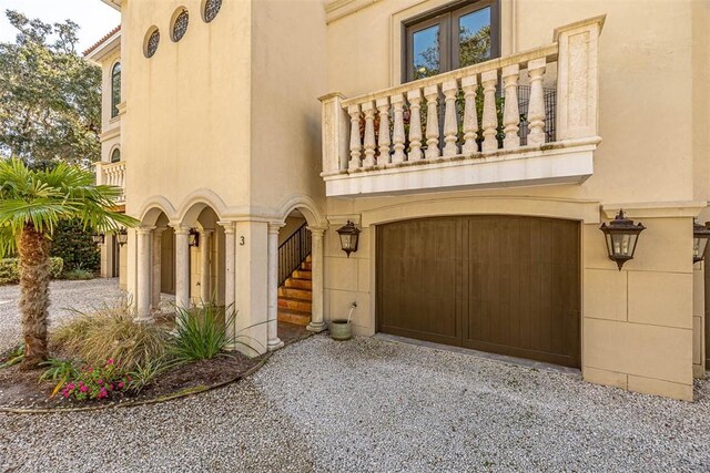 3100 Prince Ln, Saint Simons Island, GA 31522 - view of front of house with a balcony, driveway, stucco siding, and a garage