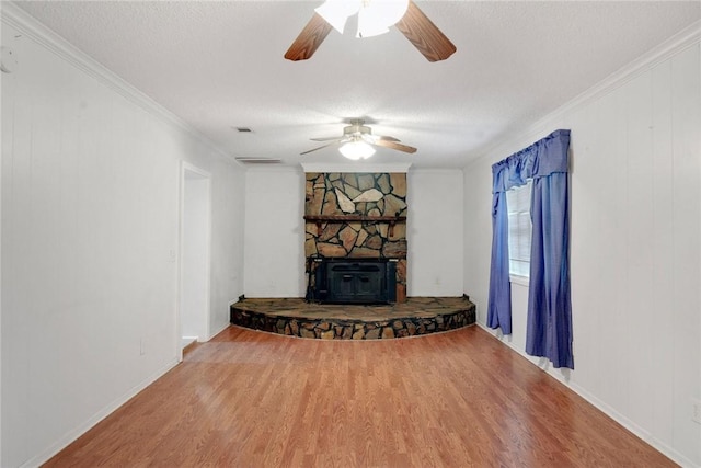 124 Ryals Rd, Brunswick, GA 31523 - living room with wood finished floors, ceiling fan, a wood stove, a textured ceiling, and ornamental molding