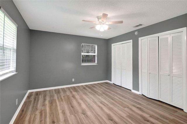 124 Ryals Rd, Brunswick, GA 31523 - unfurnished bedroom with two closets, wood finished floors, and ceiling fan