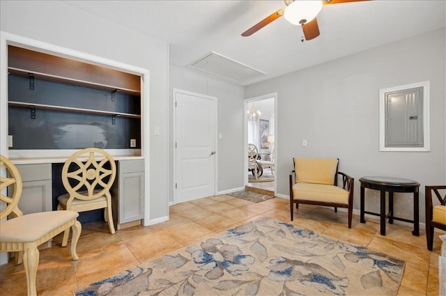 living area with attic access, electric panel, light tile patterned floors, and ceiling fan